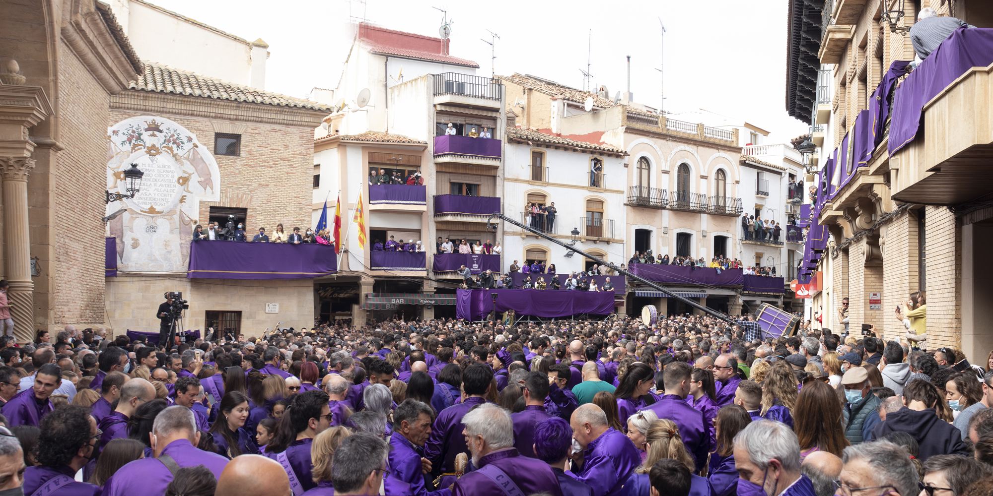 Plaza de Calanda llena de tamborileros con túnicas moradas durante la Semana Santa